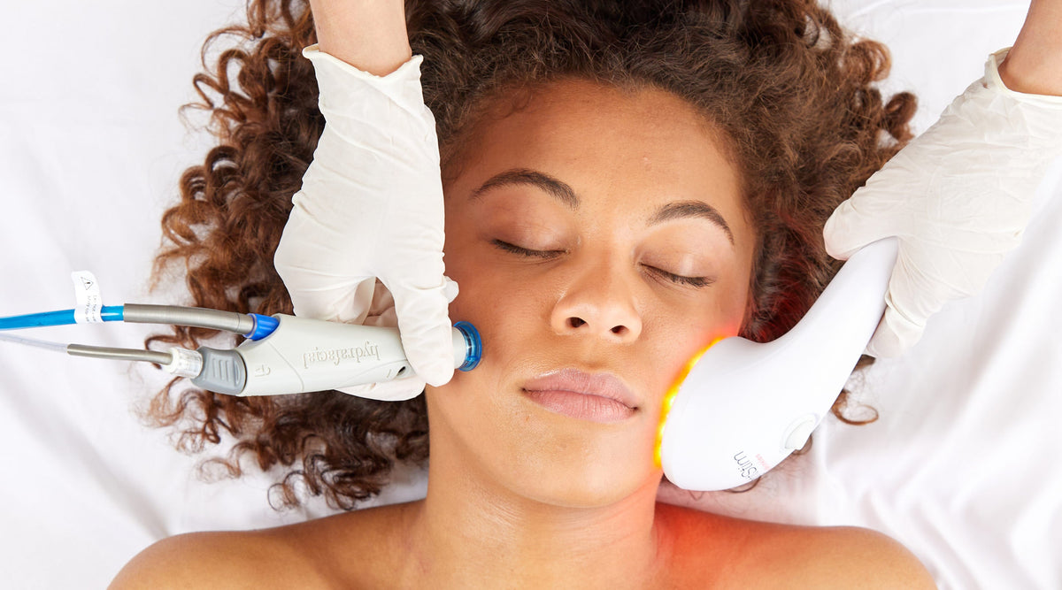 A woman is receiving a combination facial treatment of LightStim LED therapy and HydraFacial